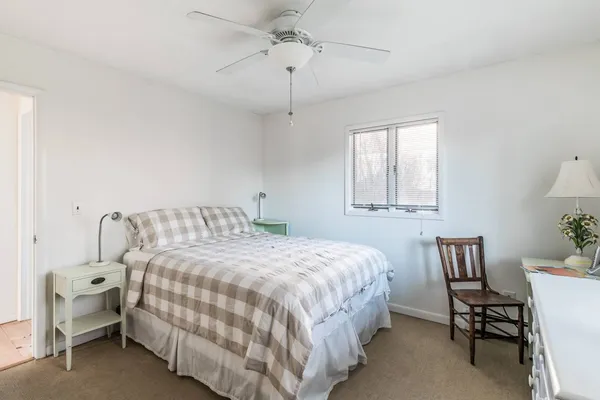 a bedroom with a bed chairs and a window