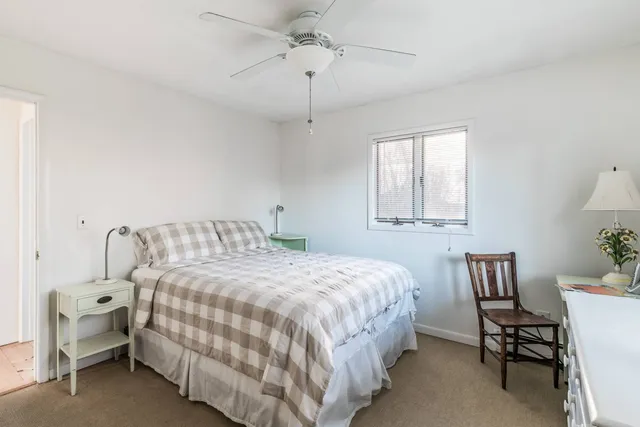 a bedroom with a bed chairs and a window