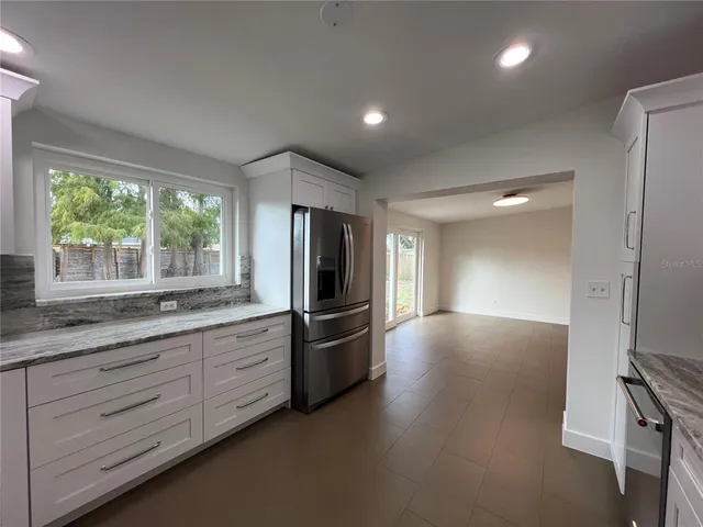 a kitchen with granite countertop a refrigerator and a sink
