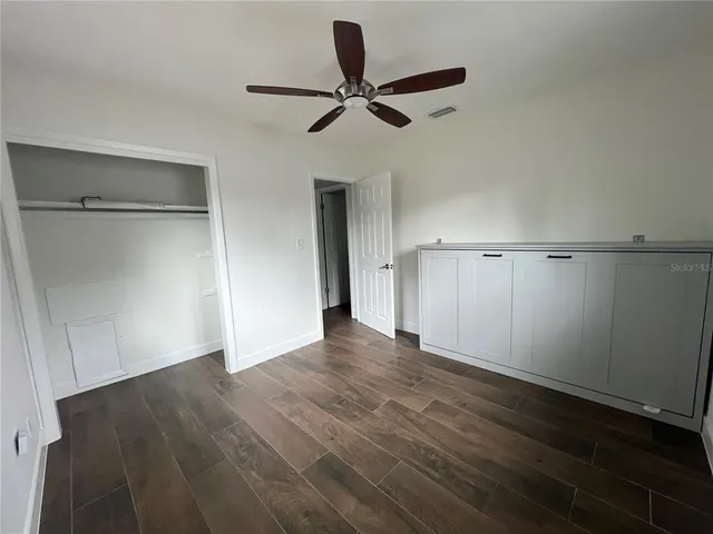 a view of a livingroom with a hardwood floor and a ceiling fan