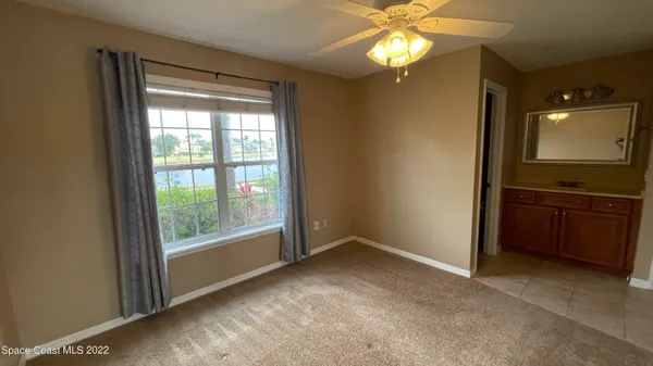 an empty room with closet and a ceiling fan