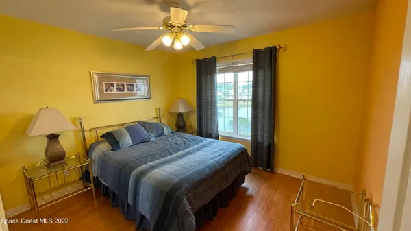 a bedroom with a bed chandelier and a window