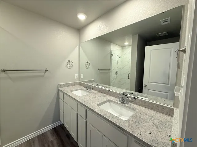 a bathroom with a granite countertop sink and a mirror