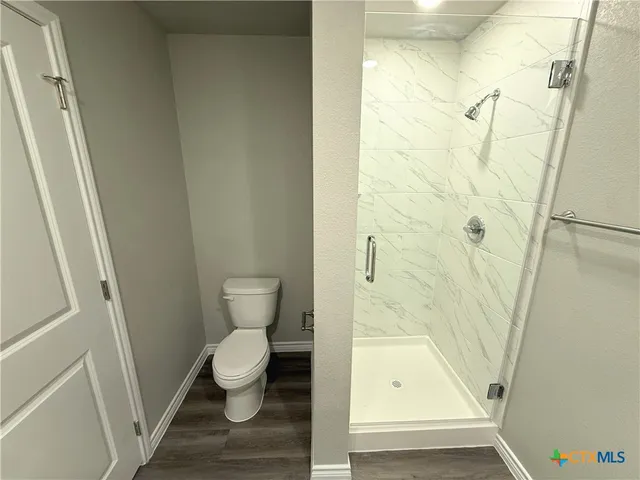 a bathroom with a toilet and a shower