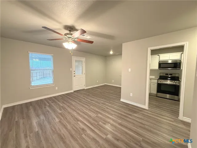 wooden floor in an empty room with a window
