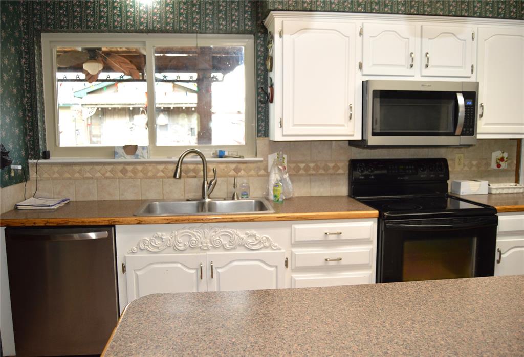 1012 Meridith Drive Terrell, TX 75160 - Photo 11 of 26 Kitchen featuring white cabinetry, stainless steel appliances, and backsplash