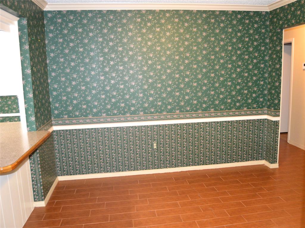 1012 Meridith Drive Terrell, TX 75160 - Photo 15 of 26 Formal Dining room with ornamental molding, wallpapered walls, and dark type flooring