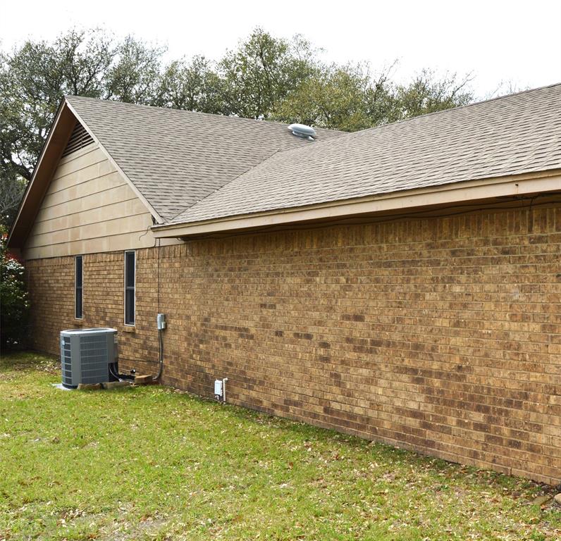 1012 Meridith Drive Terrell, TX 75160 - Photo 4 of 26 View of side of property featuring brick siding, a lawn, and roof with shingles