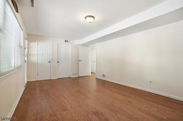 a view of an empty room with wooden floor
