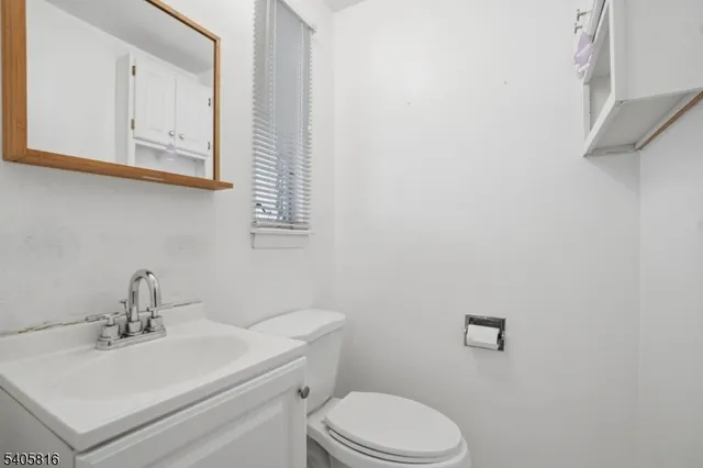a bathroom with a toilet a sink and mirror
