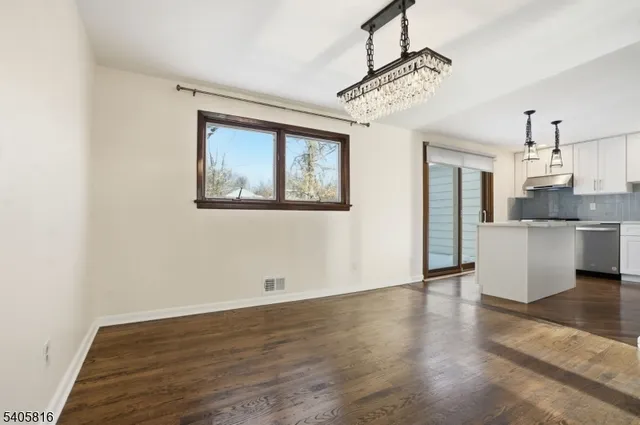 a view of a kitchen with wooden floor and a refrigerator
