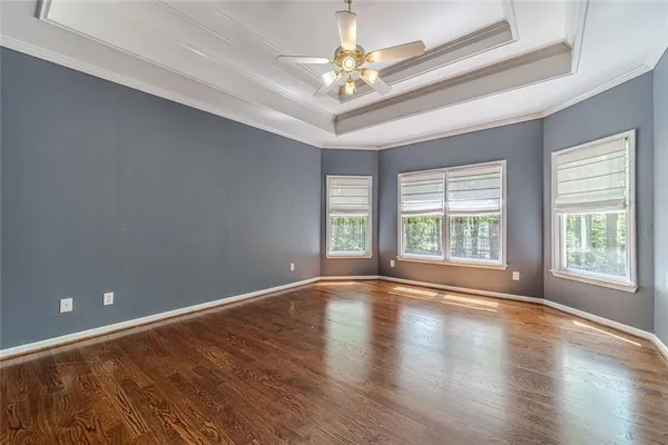 a view of an empty room with window and chandelier fan