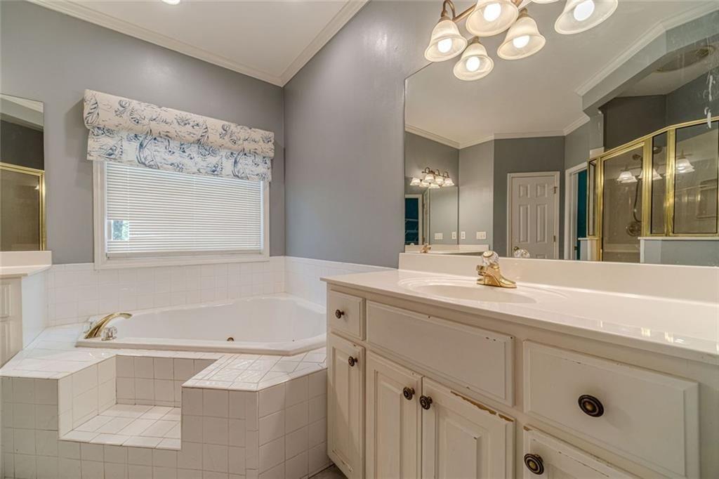 395 Amberbrook Circle Grayson, GA 30017 - Photo 23 of 70 a bathroom with a tub a sink and mirror