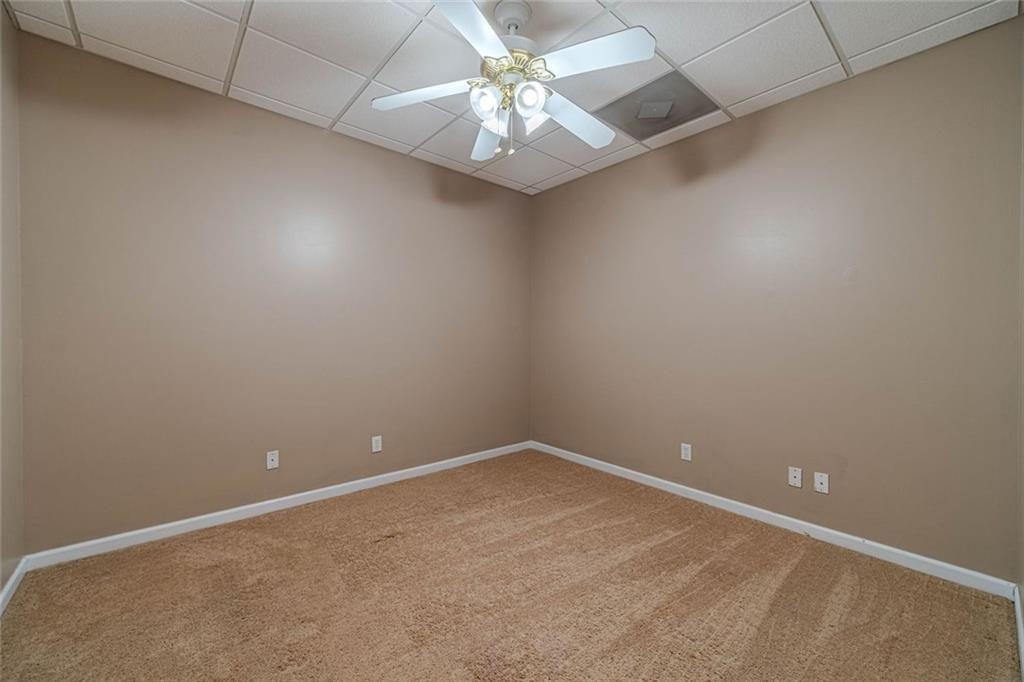395 Amberbrook Circle Grayson, GA 30017 - Photo 42 of 70 an empty room with a chandelier fan and windows