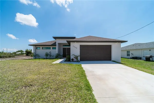 a front view of a house with a yard and garage