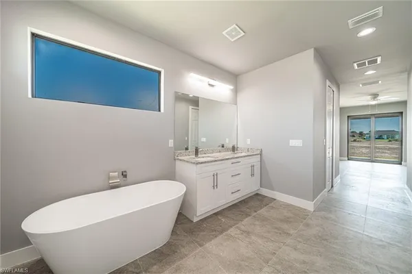 a large spacious bathroom with a double vanity sink a mirror and a bathtub