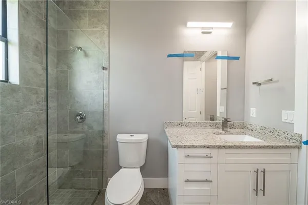 a bathroom with a granite countertop sink toilet and shower