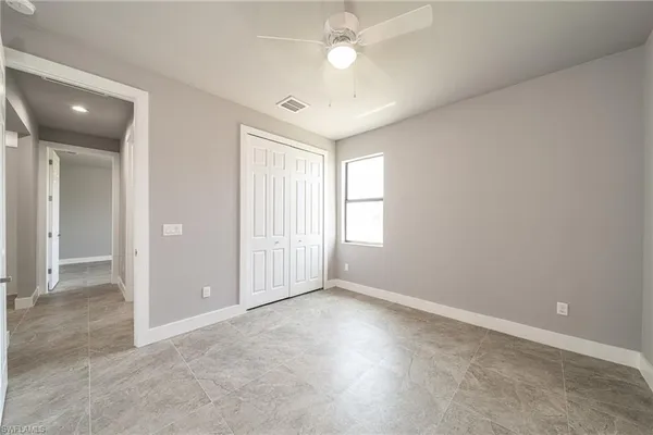 an empty room with fan and windows