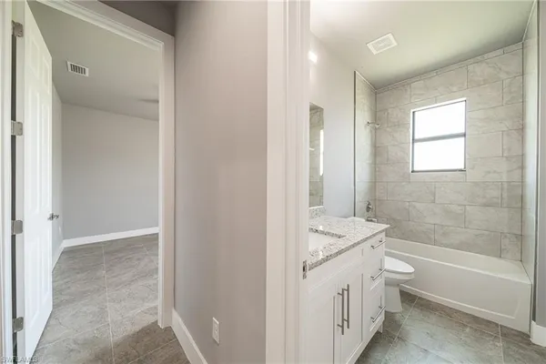 a bathroom with a granite countertop sink a toilet and shower