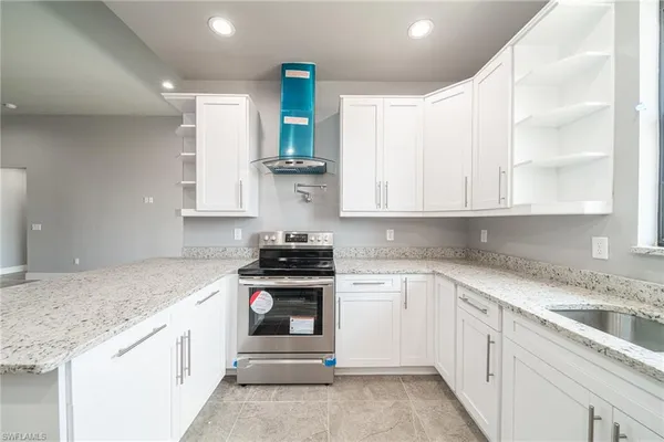 a kitchen with granite countertop white cabinets and white appliances