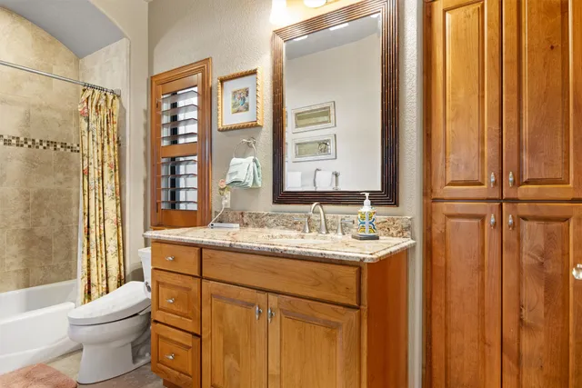 a bathroom with a granite countertop sink toilet and shower