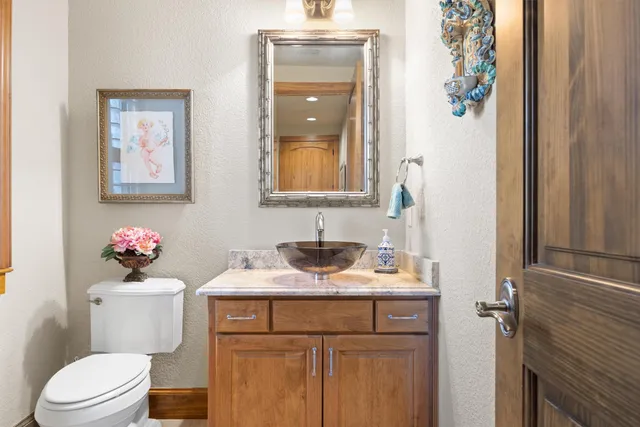 a bathroom with a sink vanity mirror and toilet