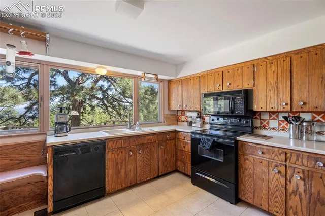 a kitchen with stainless steel appliances a large counter top a stove a sink and a refrigerator