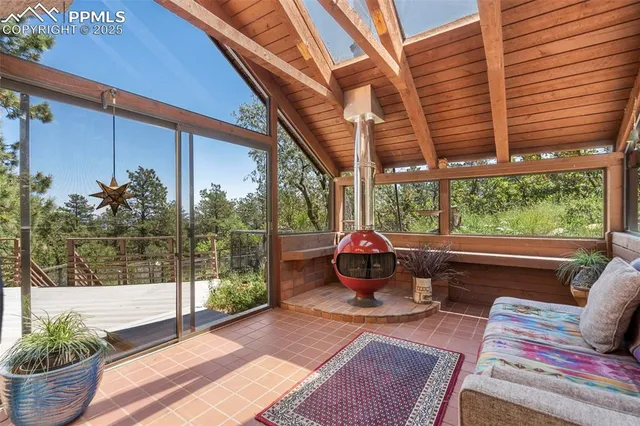 a bedroom with a bed a balcony a large window and furniture