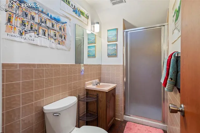 a hallway with painting and a refrigerator