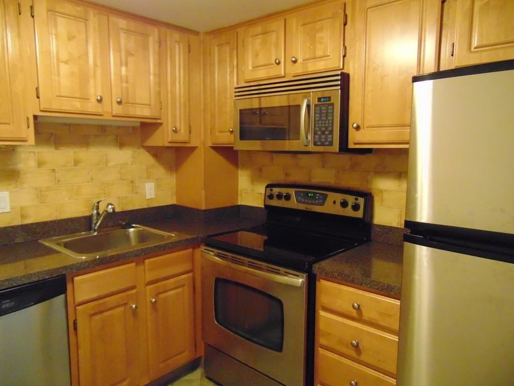 a kitchen with granite countertop cabinets stainless steel appliances and a sink