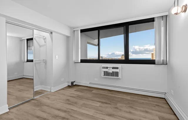 an empty room with wooden floor and a window