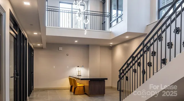 a view of staircase with lots of frames and chairs