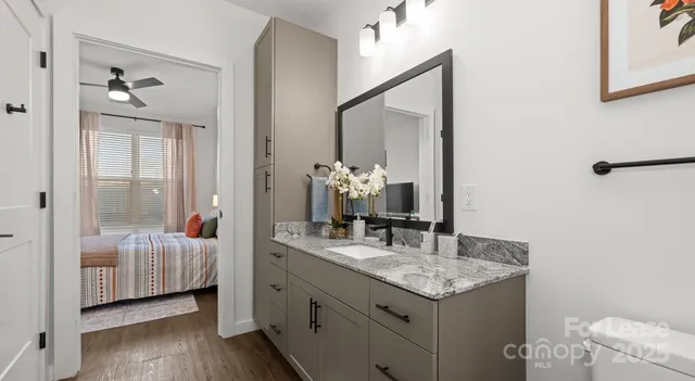 a kitchen with stainless steel appliances a dining table chairs sink and cabinets