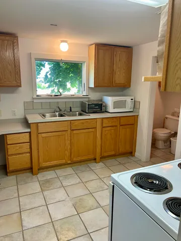 a kitchen with a refrigerator sink and cabinets