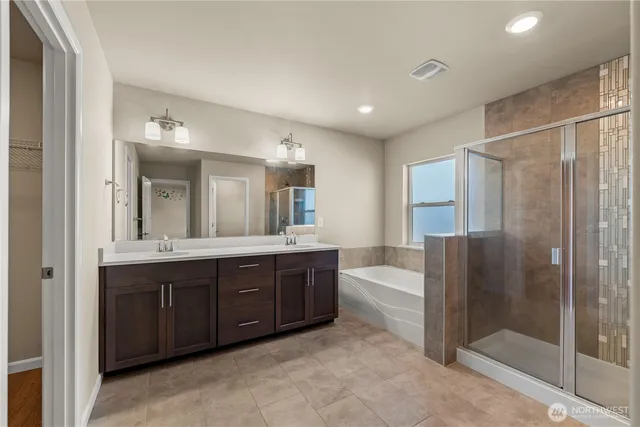 a spacious bathroom with a tub sink and mirror