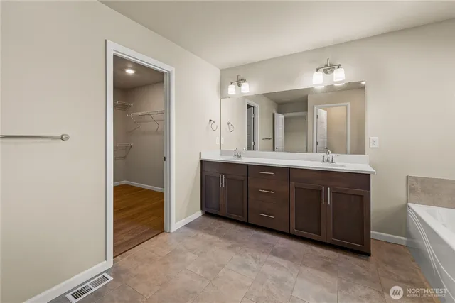 a spacious bathroom with a double vanity sink mirror and double