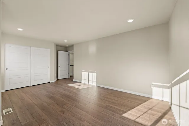 a view of an empty room with wooden floor