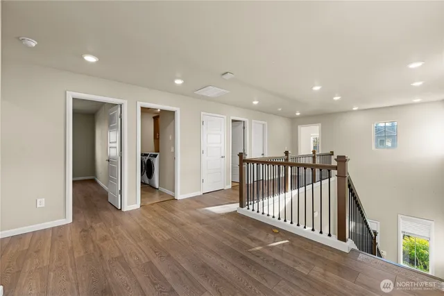 a view of a hallway with wooden floor and windows