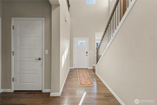 a view of a hallway with wooden floor and entryway