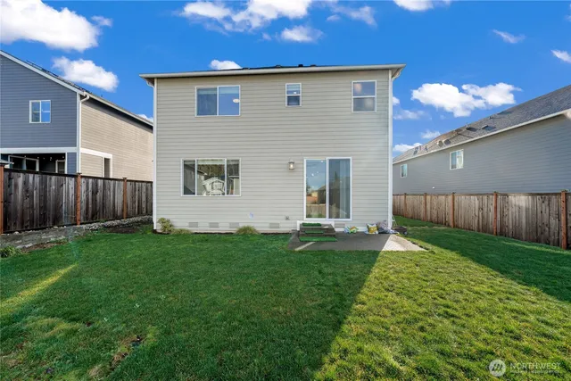 a view of a backyard with plants and wooden fence