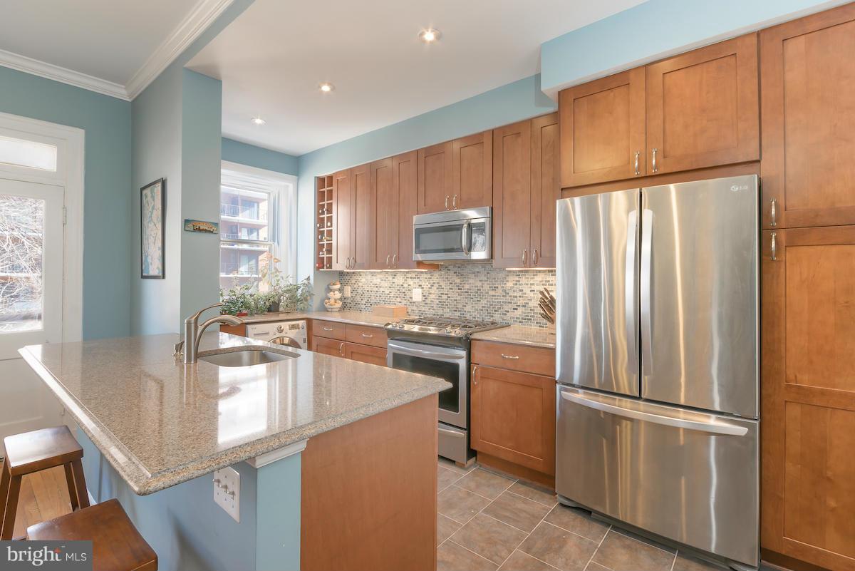 1734 P Street Northwest, Unit 46 Washington, DC 20036 - Photo 13 of 16 a kitchen with stainless steel appliances granite countertop a refrigerator a stove a sink and a refrigerator