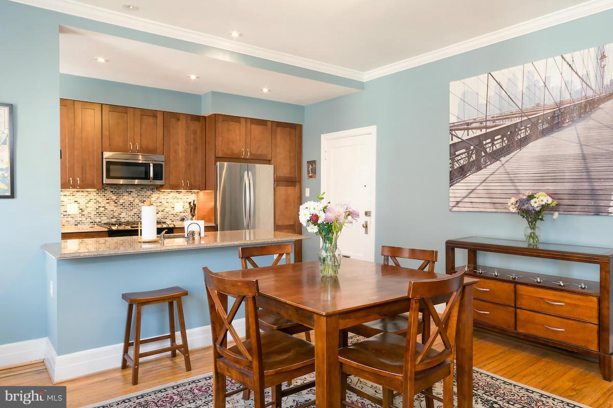 1734 P Street Northwest, Unit 46 Washington, DC 20036 - Photo 9 of 16 a kitchen with stainless steel appliances granite countertop a dining table and chairs