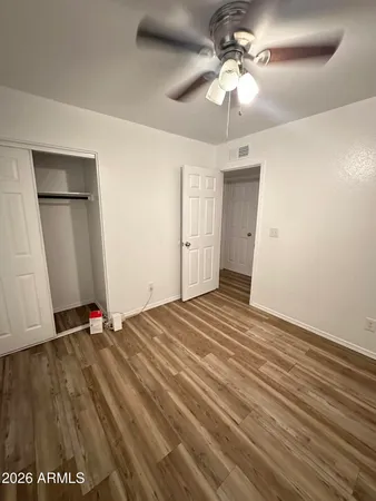 a view of an empty room with a chandelier fan