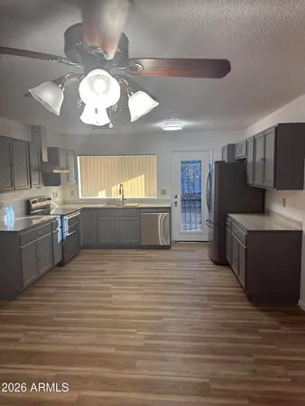 a large kitchen with wooden floor and stainless steel appliances