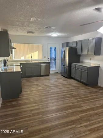 a kitchen with stainless steel appliances wooden cabinets a sink and a refrigerator