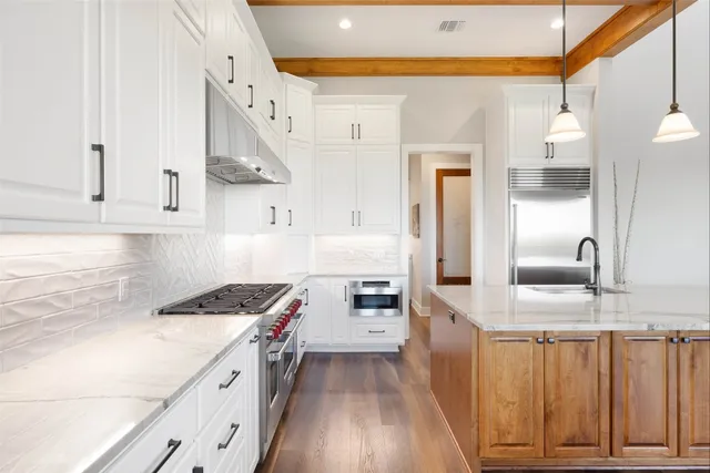 a kitchen with granite countertop a sink stove and cabinets