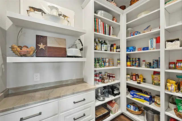 a kitchen with stainless steel appliances granite countertop white cabinets and a window