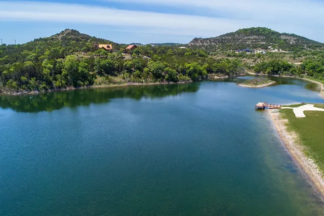 an aerial view of residential houses with outdoor space and lake view