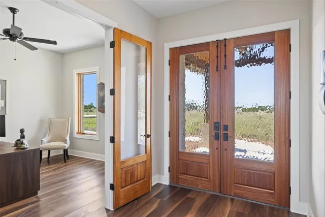 a view of a hallway with wooden floor and windows