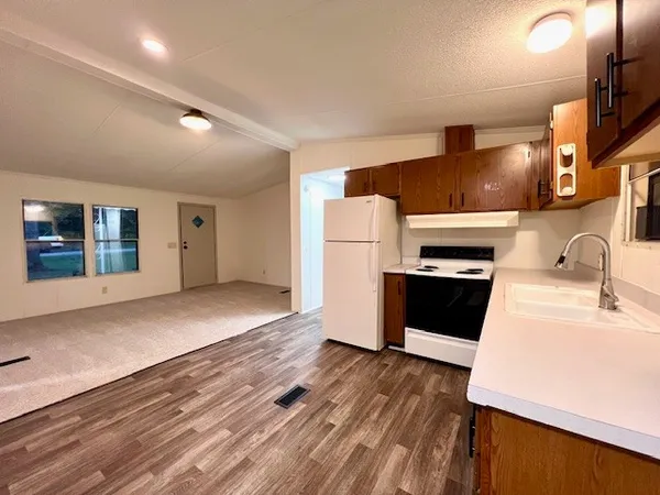 a kitchen with a refrigerator and a stove top oven
